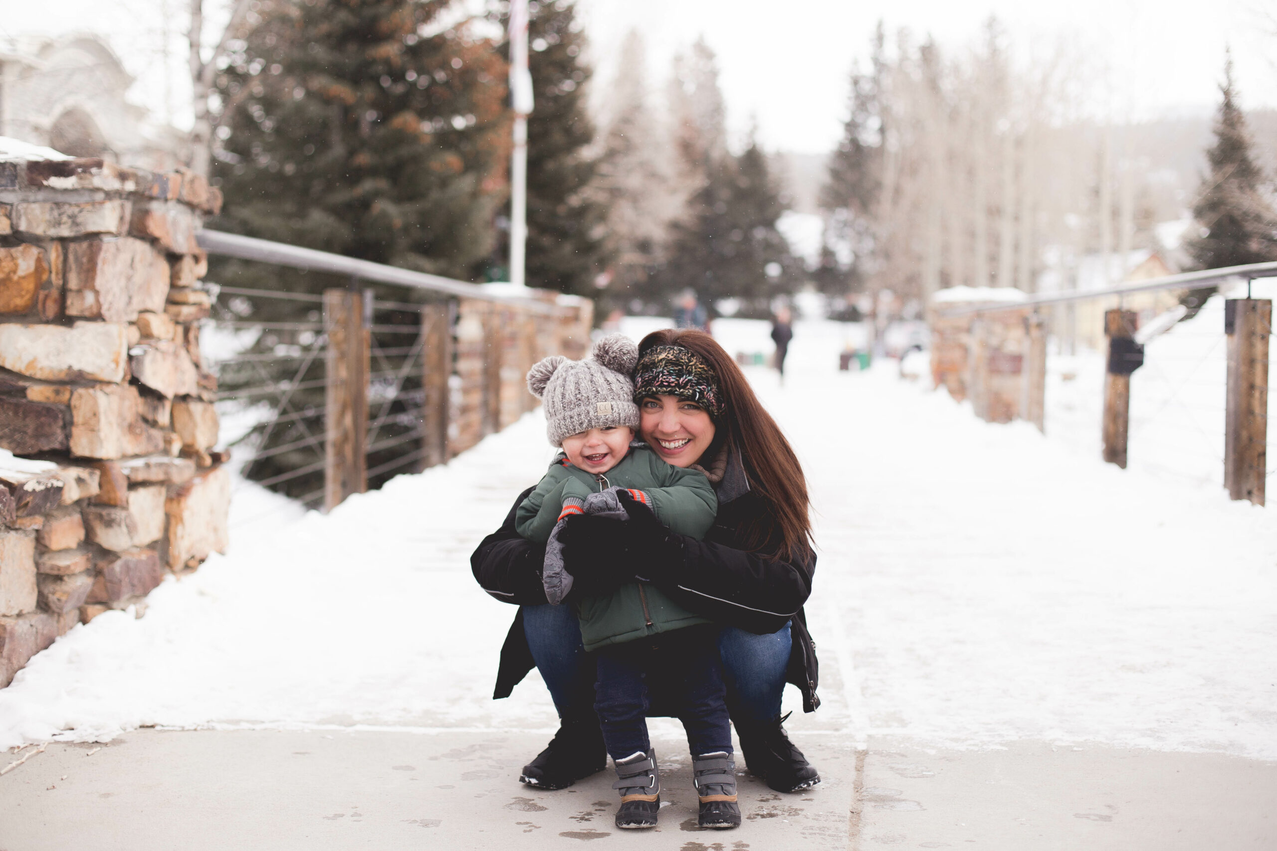 mom and son in snow hugging in Main Street in Breckenridge mom and son in snow hugging in Main Street in Breckenridge