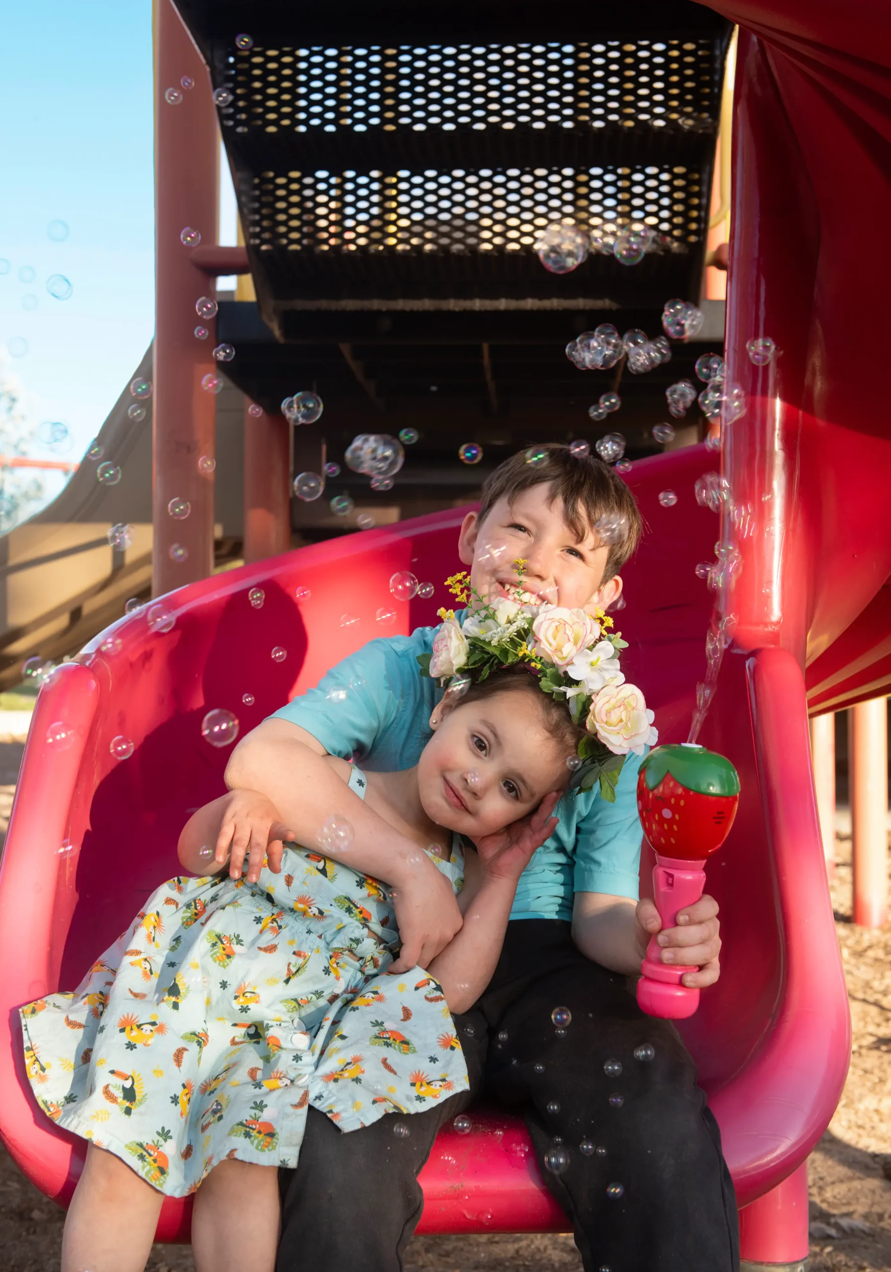 Leo and Lucy sitting on slide