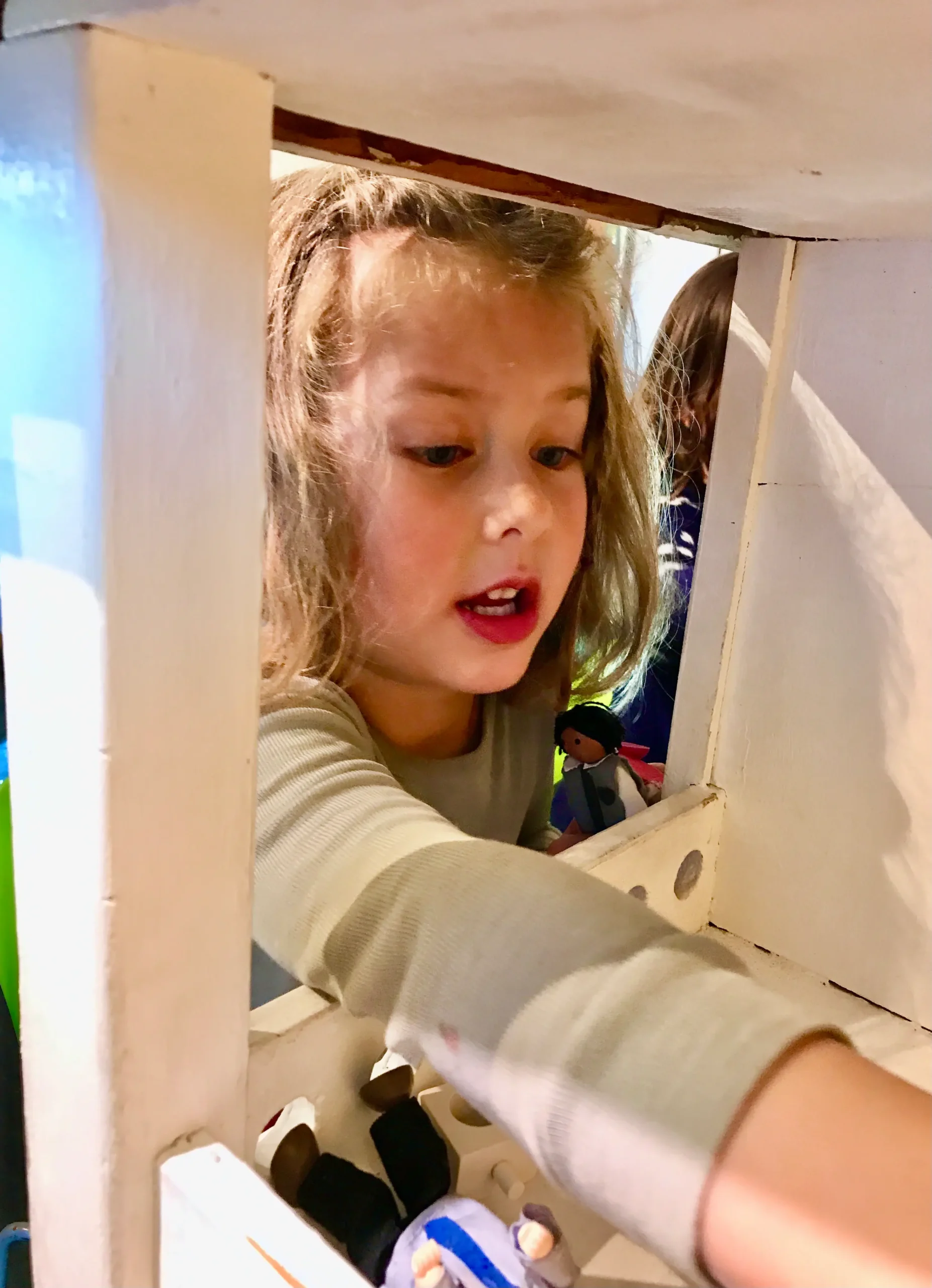 A four-year-old arranges the furnishings of the dollhouse at the Santa Fe Children's Museum.