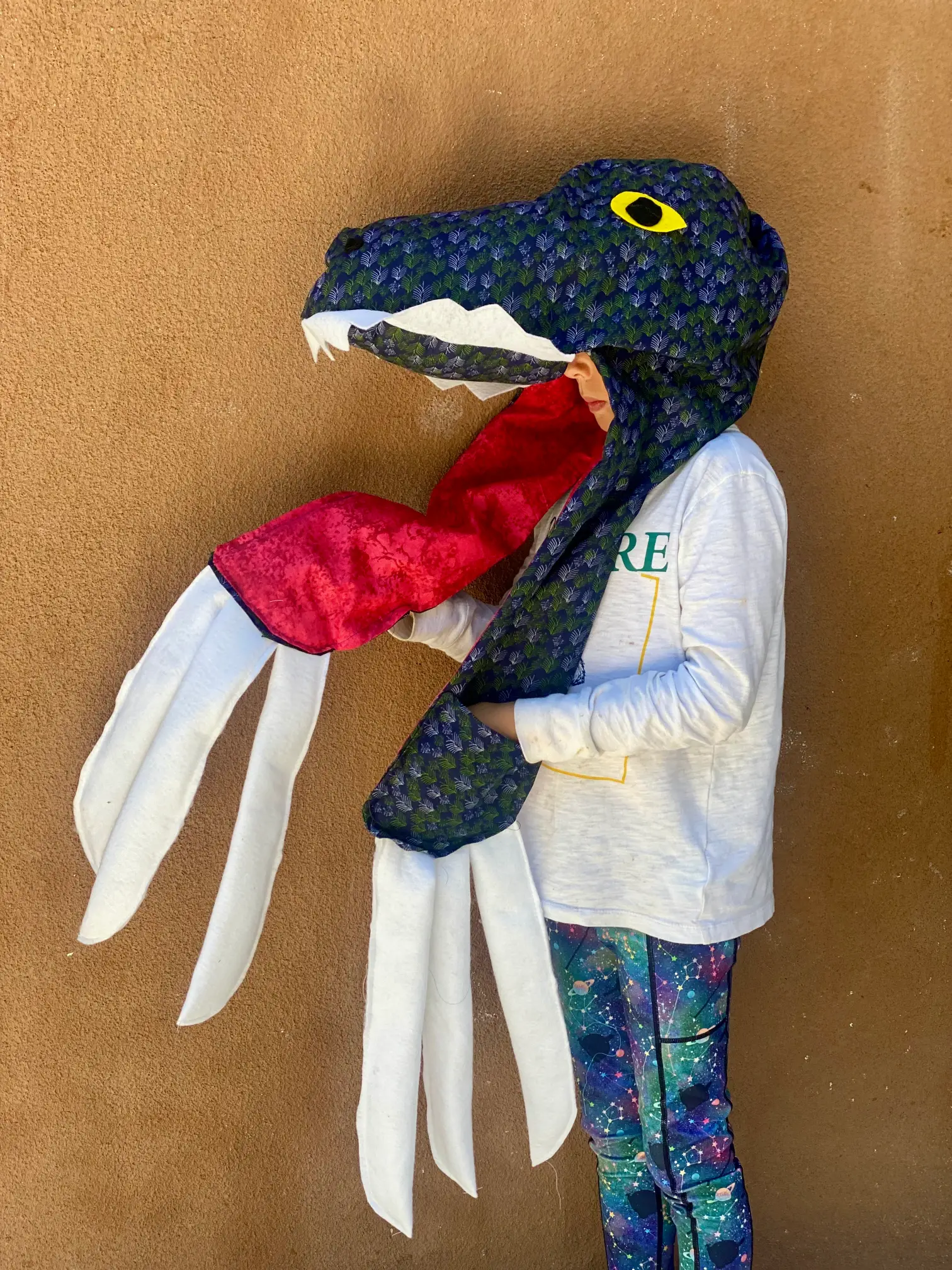 student with dinosaur hat